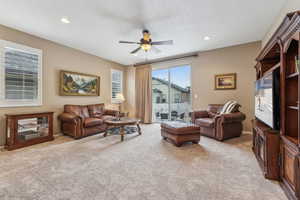 Living room featuring light carpet and ceiling fan