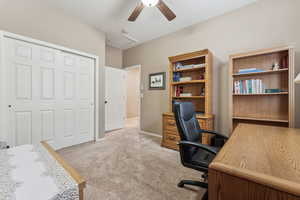 Office with light carpet and ceiling fan