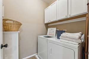 Clothes washing area with cabinets and washer and dryer