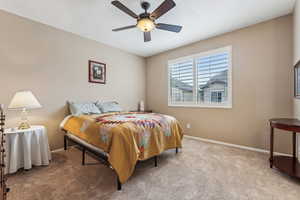 Carpeted bedroom with ceiling fan