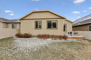 Snow covered rear of property featuring a deck