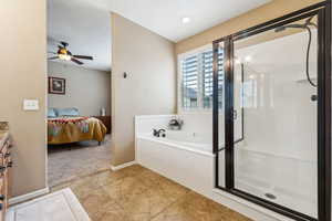 Bathroom with vanity, tile patterned floors, independent shower and bath, and ceiling fan