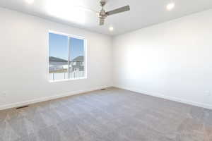 Carpeted spare room with ceiling fan