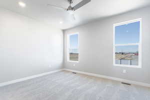 Unfurnished room featuring carpet floors and ceiling fan