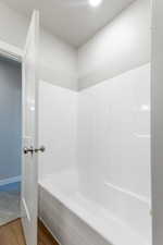 Bathroom with hardwood / wood-style flooring and separate shower and tub