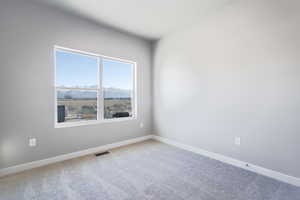 Spare room featuring a mountain view and carpet flooring