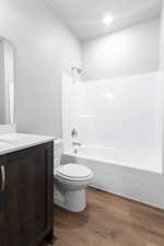 Full bathroom featuring vanity, hardwood / wood-style floors, toilet, and shower / bath combination