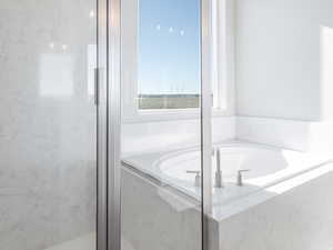 Bathroom featuring shower with separate bathtub