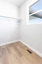 Spacious closet featuring light hardwood / wood-style flooring