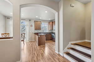 Kitchen with appliances with stainless steel finishes, a kitchen breakfast bar, sink, and light wood-type flooring