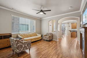 Living room featuring crown molding, hardwood / wood-style floors, and a wealth of natural light