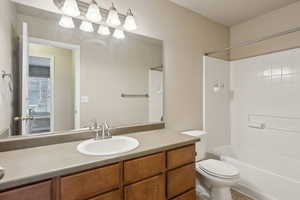 Full bathroom featuring vanity, tub / shower combination, and toilet