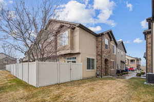 View of property exterior with central AC and a lawn