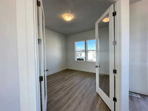Unfurnished room with dark wood-type flooring, french doors, and a textured ceiling