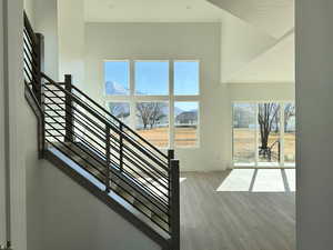 Stairway with hardwood / wood-style flooring and a high ceiling