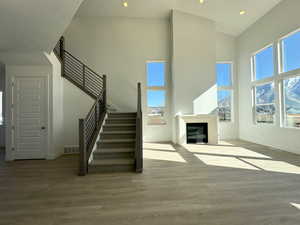 Unfurnished living room featuring a high ceiling and hardwood / wood-style flooring