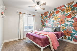 Carpeted bedroom featuring ceiling fan