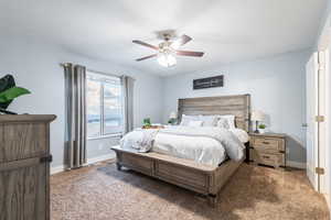 Carpeted bedroom featuring ceiling fan