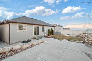 Rear view of property featuring central AC unit, a patio area, and a water view