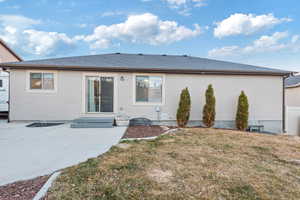 Rear view of house with a patio and a lawn