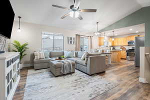 Living room featuring vaulted ceiling, hardwood / wood-style floors, and ceiling fan