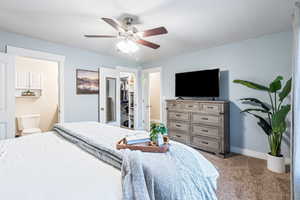 Bedroom with ceiling fan, carpet flooring, connected bathroom, a walk in closet, and a closet