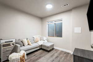 Living room with light hardwood / wood-style flooring and a textured ceiling