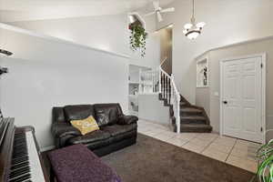 Tiled living room featuring ceiling fan and high vaulted ceiling