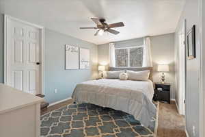 Carpeted bedroom featuring ceiling fan