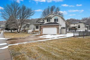 Tri-level home with a garage and a front lawn