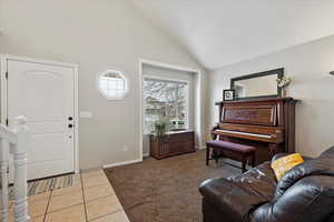 Carpeted living room featuring high vaulted ceiling