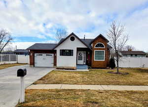 View of front of property featuring a garage and a front lawn