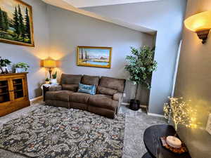 Living room featuring vaulted ceiling and carpet floors