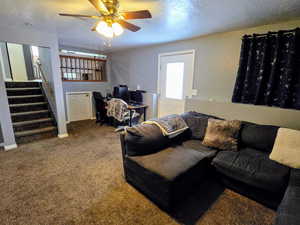 Carpeted living room featuring ceiling fan