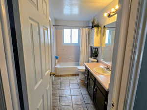 Full bathroom featuring vanity, tile patterned flooring, toilet, and shower / bath combo