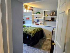 Carpeted bedroom featuring ceiling fan