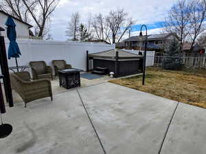 View of patio / terrace featuring a hot tub and a fire pit