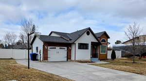 View of front of home with a garage and a front lawn