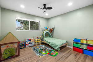 Bedroom with hardwood / wood-style floors and ceiling fan