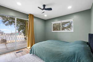 Bedroom with access to exterior, hardwood / wood-style flooring, and ceiling fan