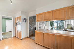 Kitchen featuring a healthy amount of sunlight, oven, and light hardwood / wood-style floors