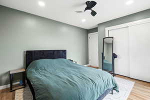 Bedroom featuring ceiling fan, light hardwood / wood-style floors, and a closet