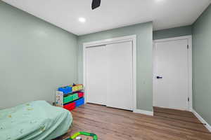 Bedroom featuring hardwood / wood-style floors, ceiling fan, and a closet