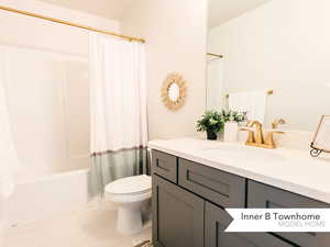 Full bathroom featuring shower / tub combo, vanity, tile patterned flooring, and toilet