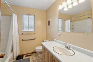 Full bathroom featuring vanity, shower / tub combo, and toilet