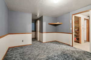 Carpeted empty room featuring a textured ceiling