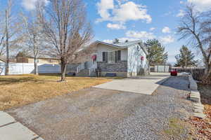 View of front of home featuring a front yard and a storage unit