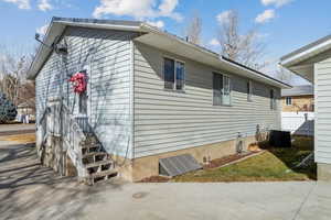 View of home's exterior with central AC and a patio area