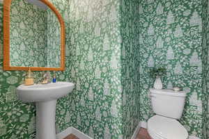 Bathroom with hardwood / wood-style flooring and toilet