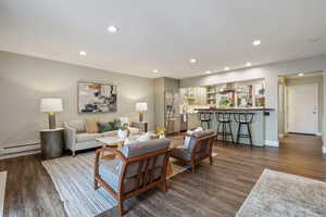 Living room featuring baseboard heating and dark hardwood / wood-style floors